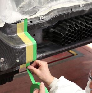 Colocación cintas adhesivas en pieza de fibra de carbono