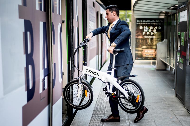 Persona subiendo al metro con una bicicleta eléctrica plegable